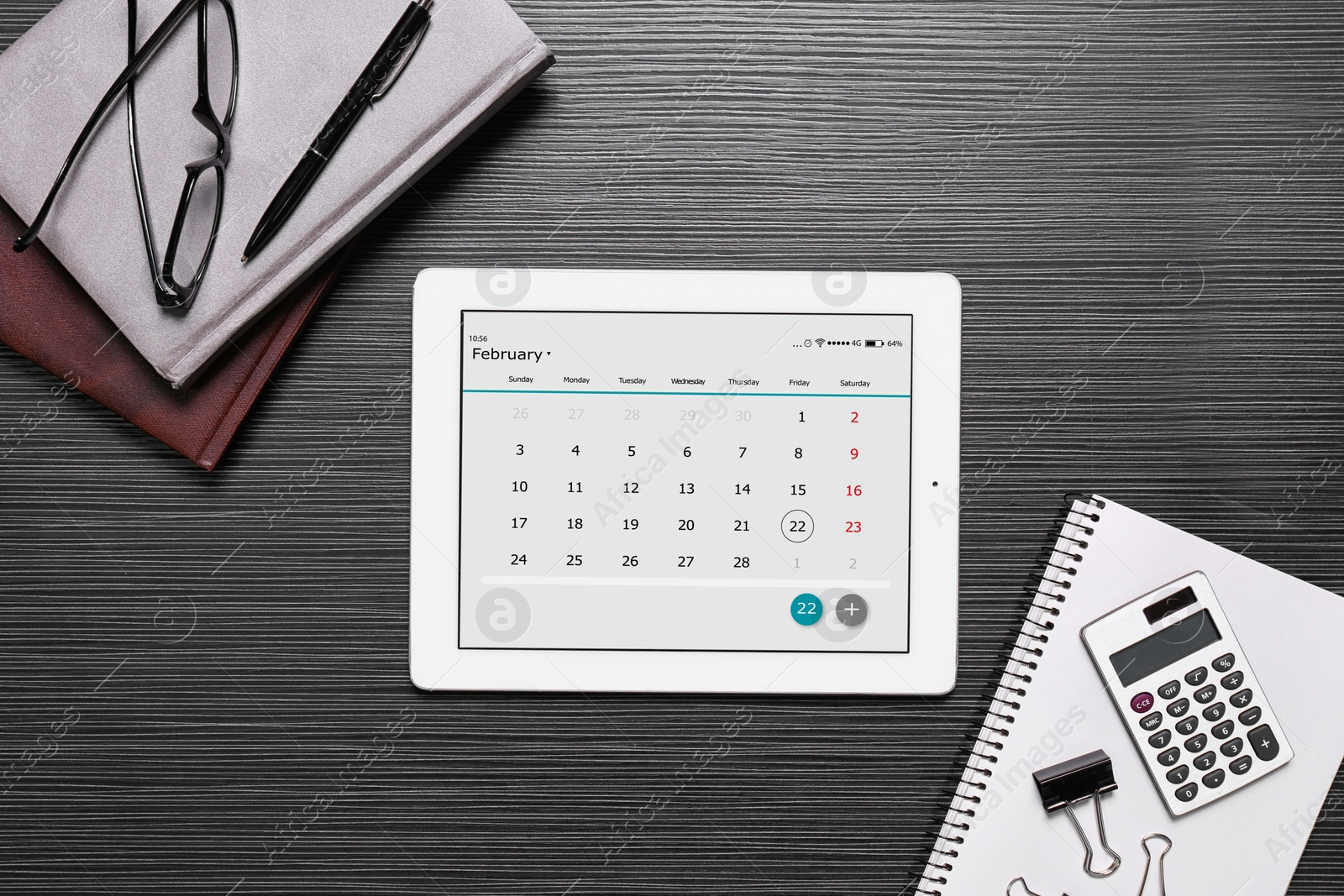 Photo of Flat lay composition of tablet with calendar app on black wooden table