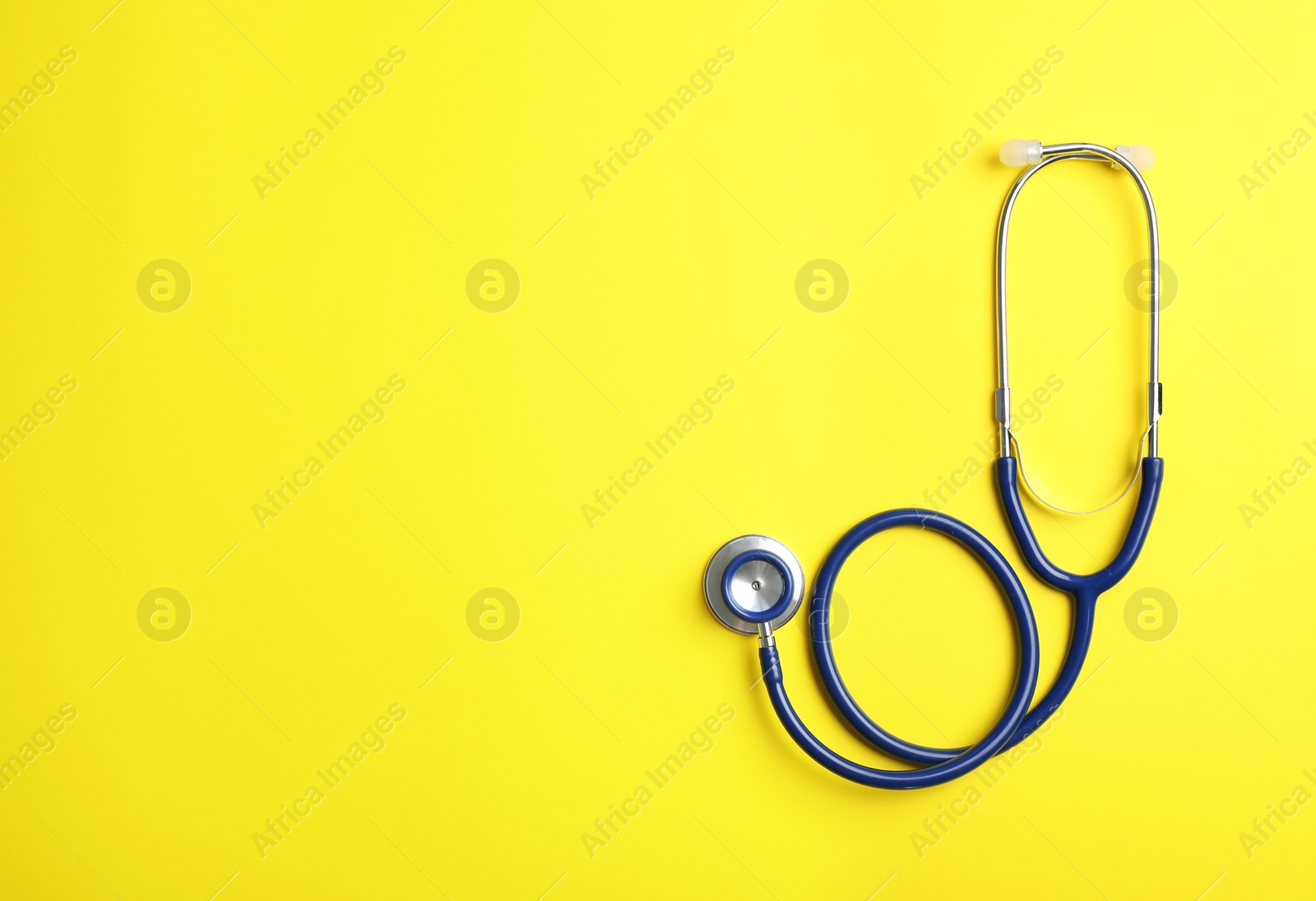 Photo of Stethoscope and space for text on color background, top view. Medical device