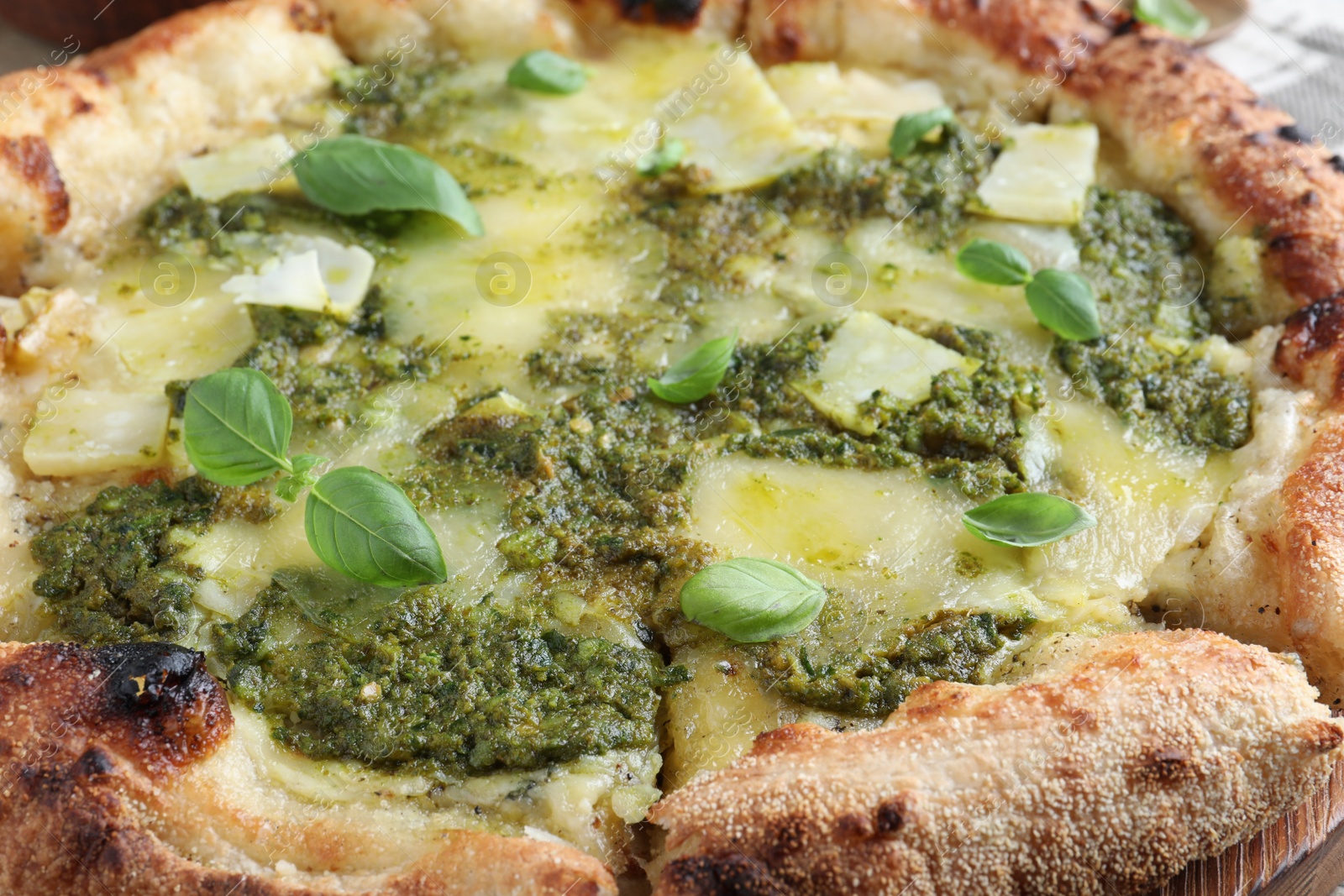 Photo of Delicious pizza with pesto, cheese and basil, closeup