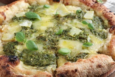 Photo of Delicious pizza with pesto, cheese and basil, closeup