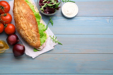 Photo of Delicious sandwich and fresh ingredients on light blue wooden table, flat lay. Space for text