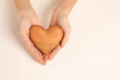 Woman holding decorative heart on white background, top view with space for text