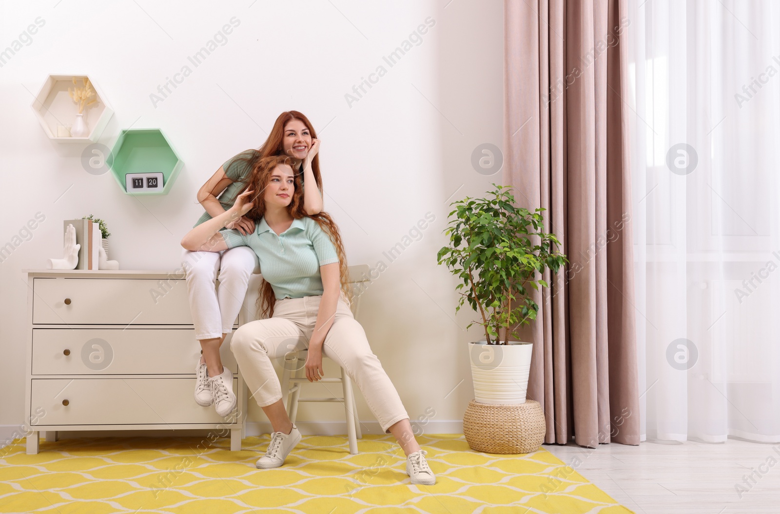 Photo of Portrait of beautiful young redhead sisters at home