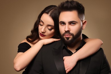 Photo of Handsome bearded man with sexy lady on light brown background