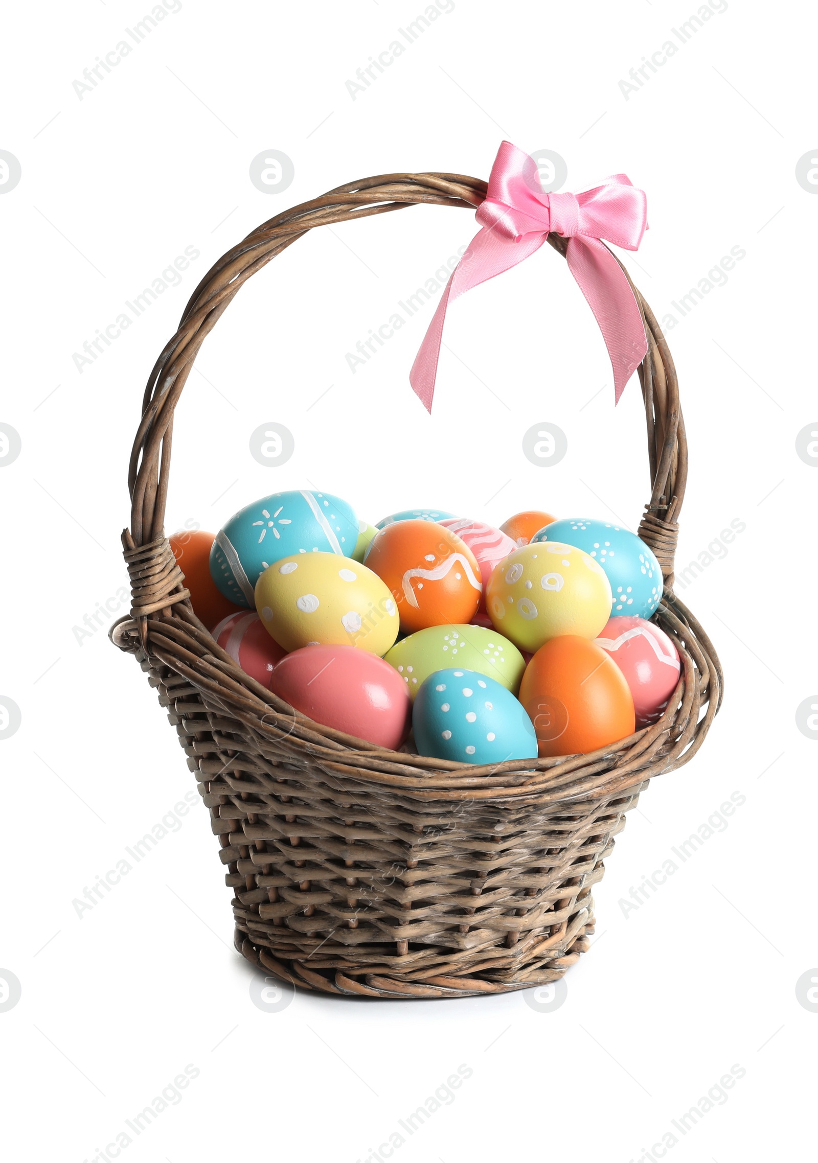 Photo of Wicker basket with painted Easter eggs on white background