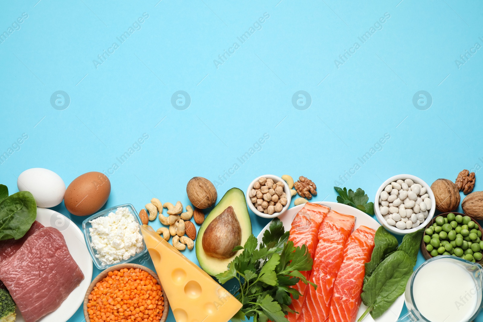 Photo of Different products rich in protein on light blue background, flat lay. Space for text