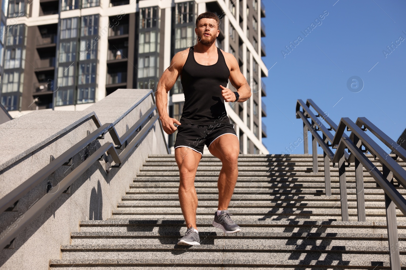 Photo of Man running down stairs outdoors on sunny day