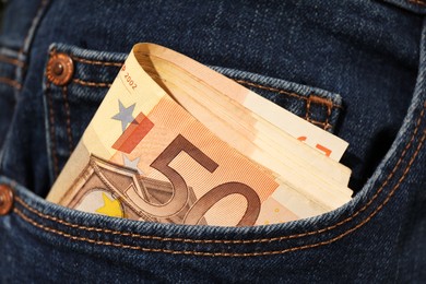 Photo of Euro banknotes in pocket of jeans, closeup. Spending money