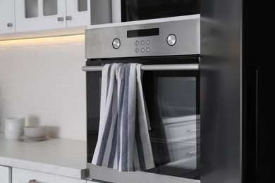 Clean striped towel on oven door in kitchen