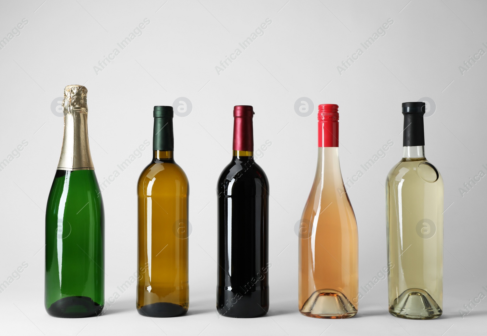 Photo of Bottles with different types of wine on light background
