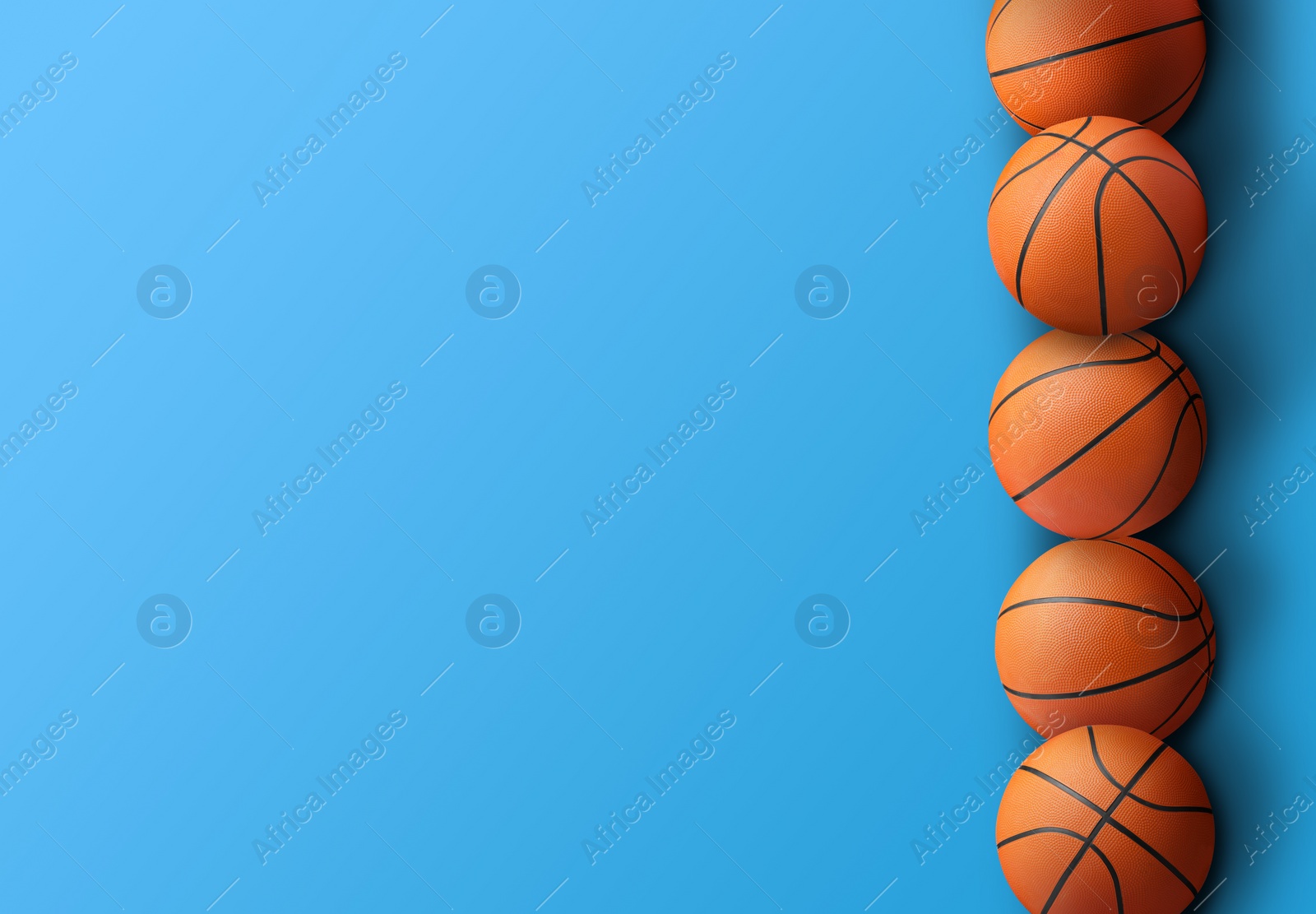 Image of Many orange basketball balls on blue background. Space for text