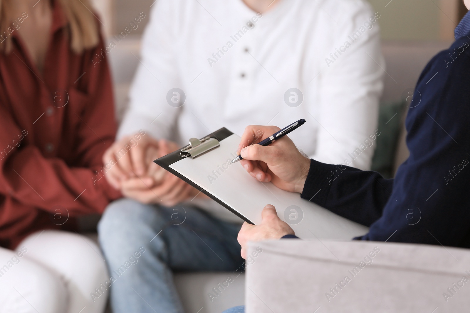 Photo of Family psychologist working with young couple in office, closeup