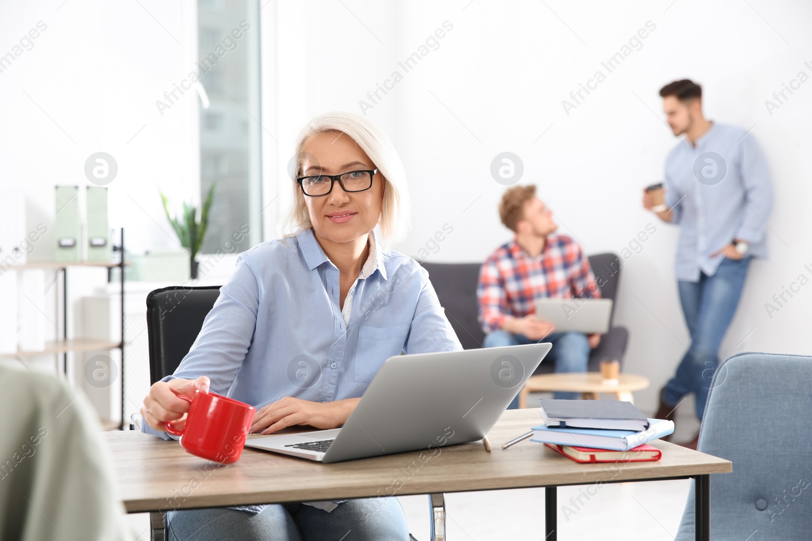 Photo of Businesswoman with colleagues working in office, space for text. Professional communication