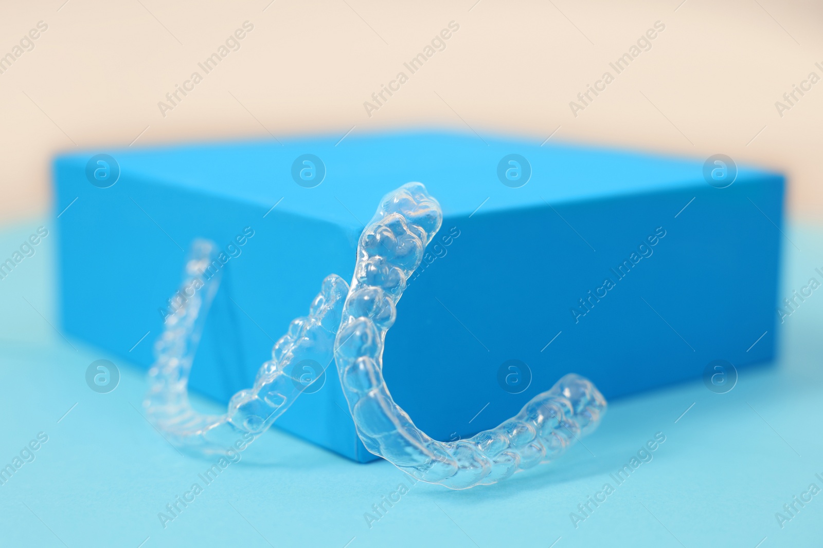 Photo of Transparent dental aligners on color background, closeup