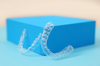 Photo of Transparent dental aligners on color background, closeup