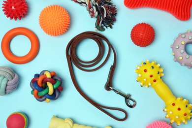 Photo of Flat lay composition with dog leash and toys on light blue background