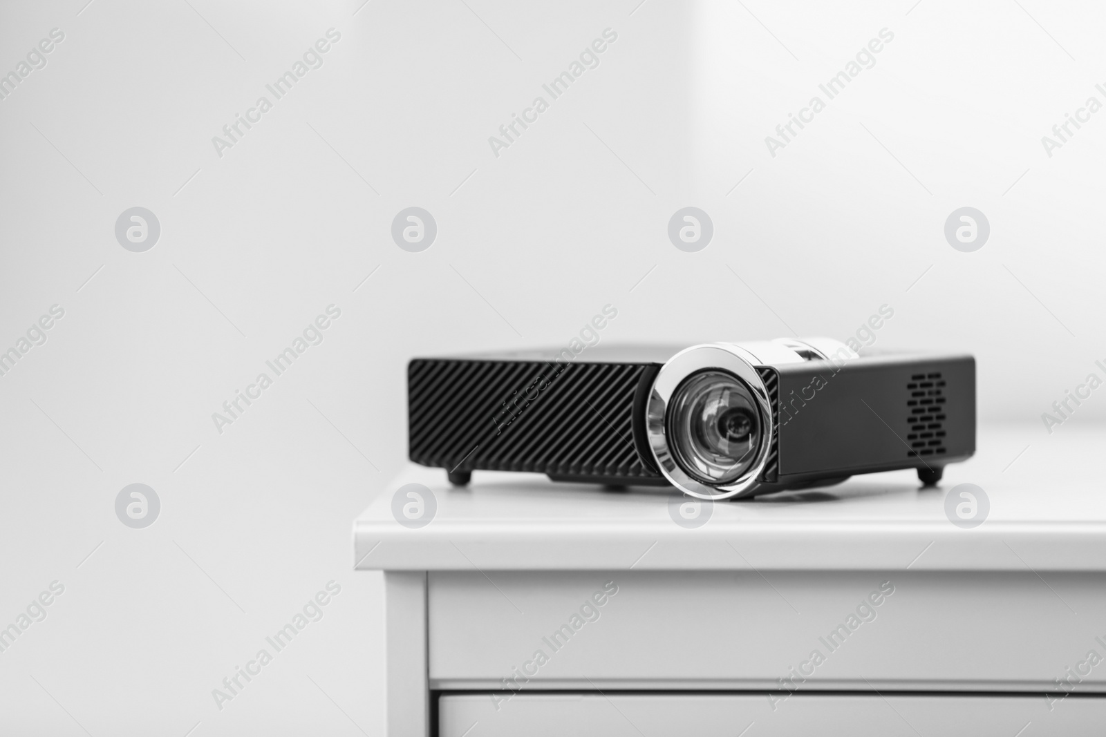 Photo of Modern video projector on white table indoors