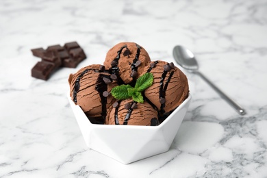 Photo of Bowl of chocolate ice cream and mint on marble table