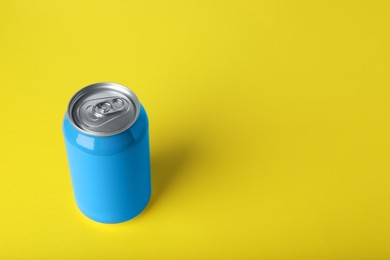 Photo of Blue can of energy drink on yellow background. Space for text