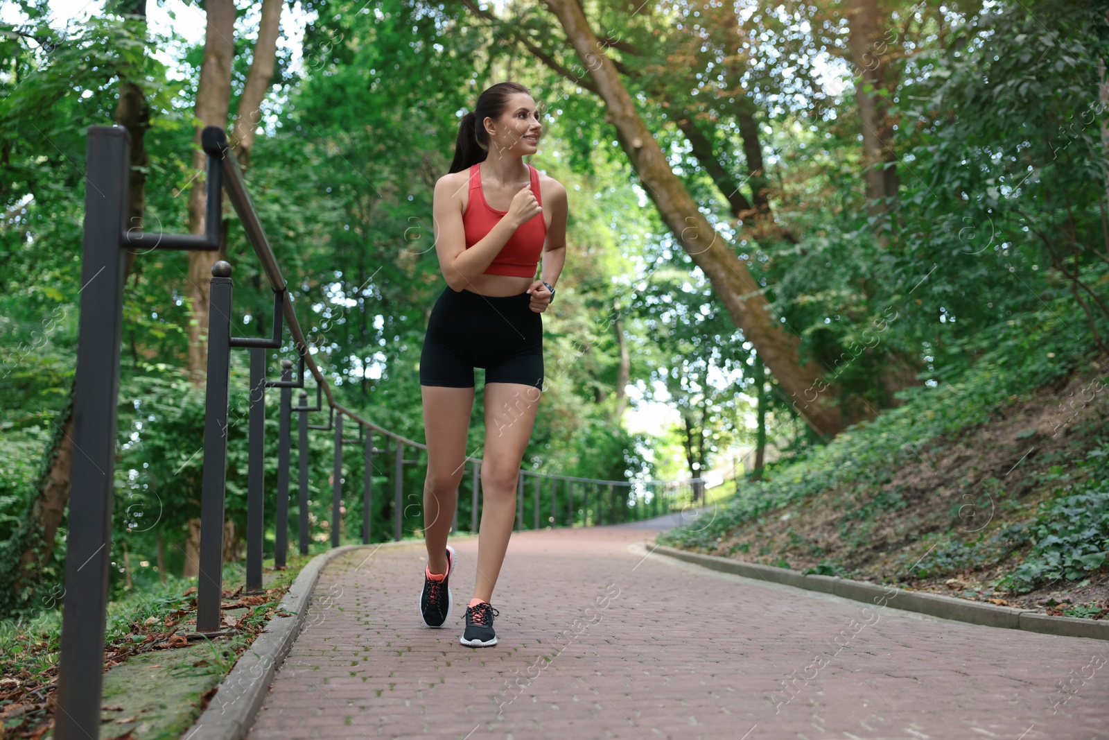 Photo of Beautiful woman in sportswear running in park. Space for text