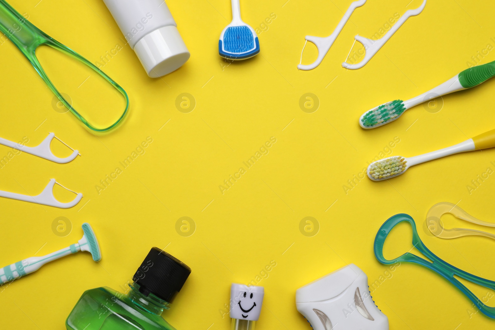 Photo of Frame of tongue cleaners and teeth care products on yellow background, flat lay. Space for text