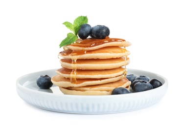 Plate of tasty pancakes with blueberries, honey and mint on white background