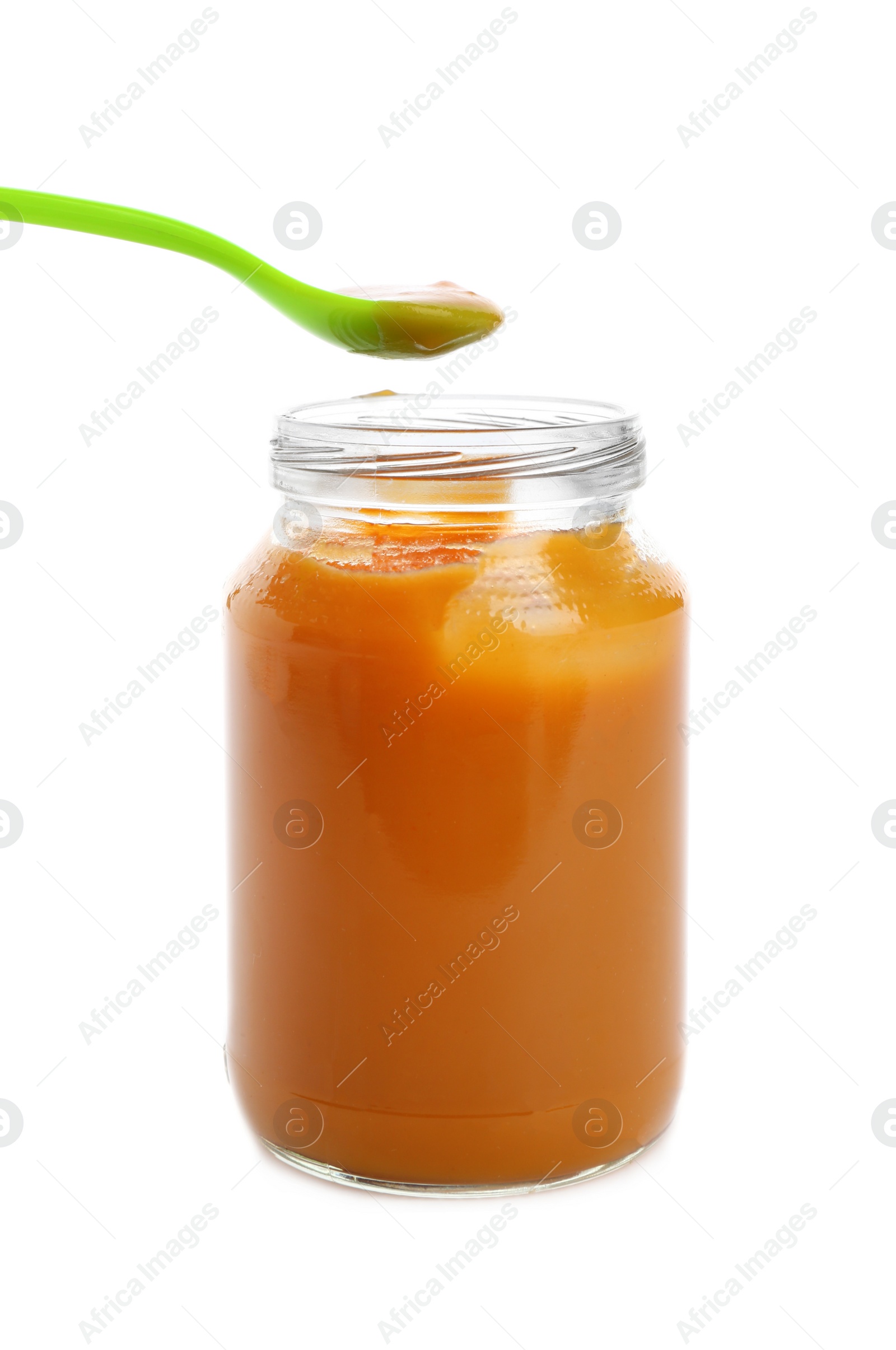 Photo of Jar and spoon with healthy baby food on white background