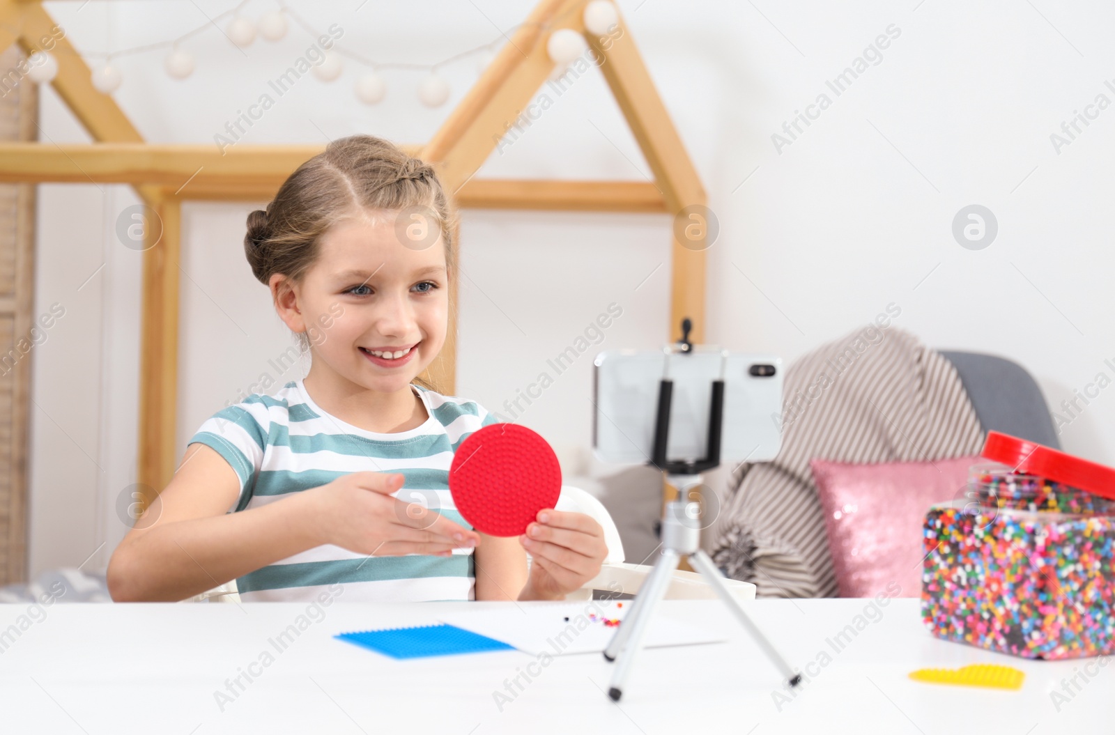 Photo of Cute little blogger with handcrafting recording video at home