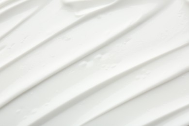 Photo of Texture of face care cream as background, top view