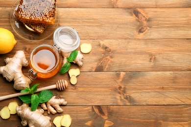 Photo of Ginger and other natural cold remedies on wooden table, flat lay. Space for text