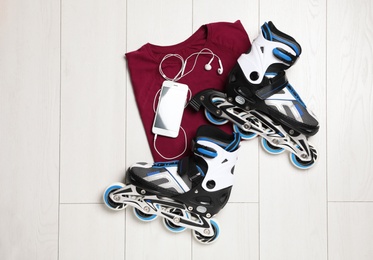 Flat lay composition with inline roller skates on wooden background