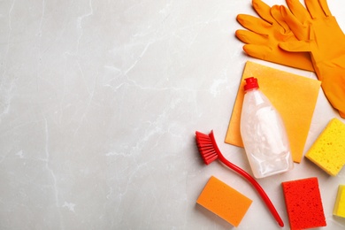 Photo of Flat lay composition with cleaning supplies for dish washing and space for text on grey background