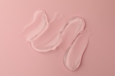 Sample of clear cosmetic gel on pink background, top view