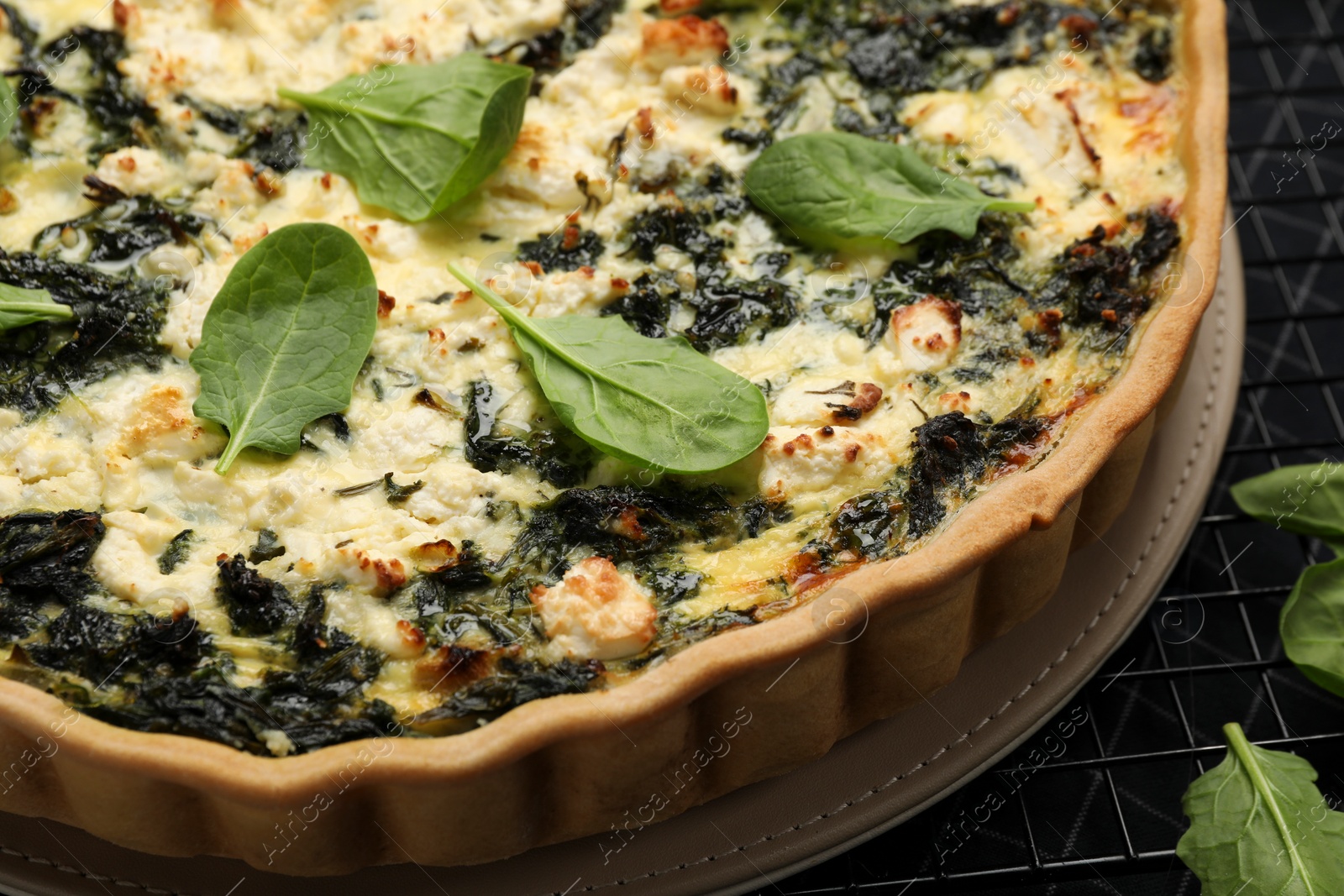 Photo of Delicious homemade spinach quiche on table, closeup