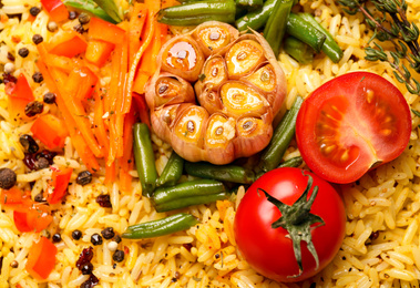 Photo of Tasty rice pilaf with vegetables as background, closeup