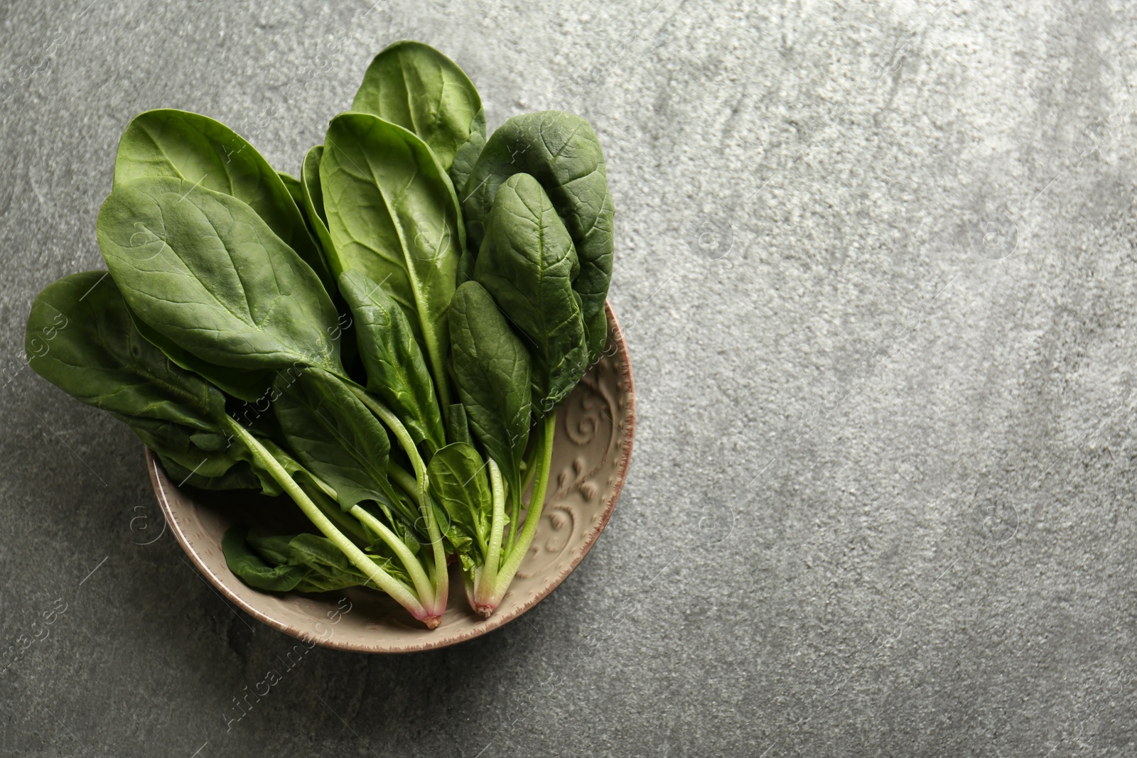 Photo of Fresh green healthy spinach leaves on grey table, top view. Space for text