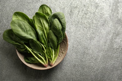 Fresh green healthy spinach leaves on grey table, top view. Space for text