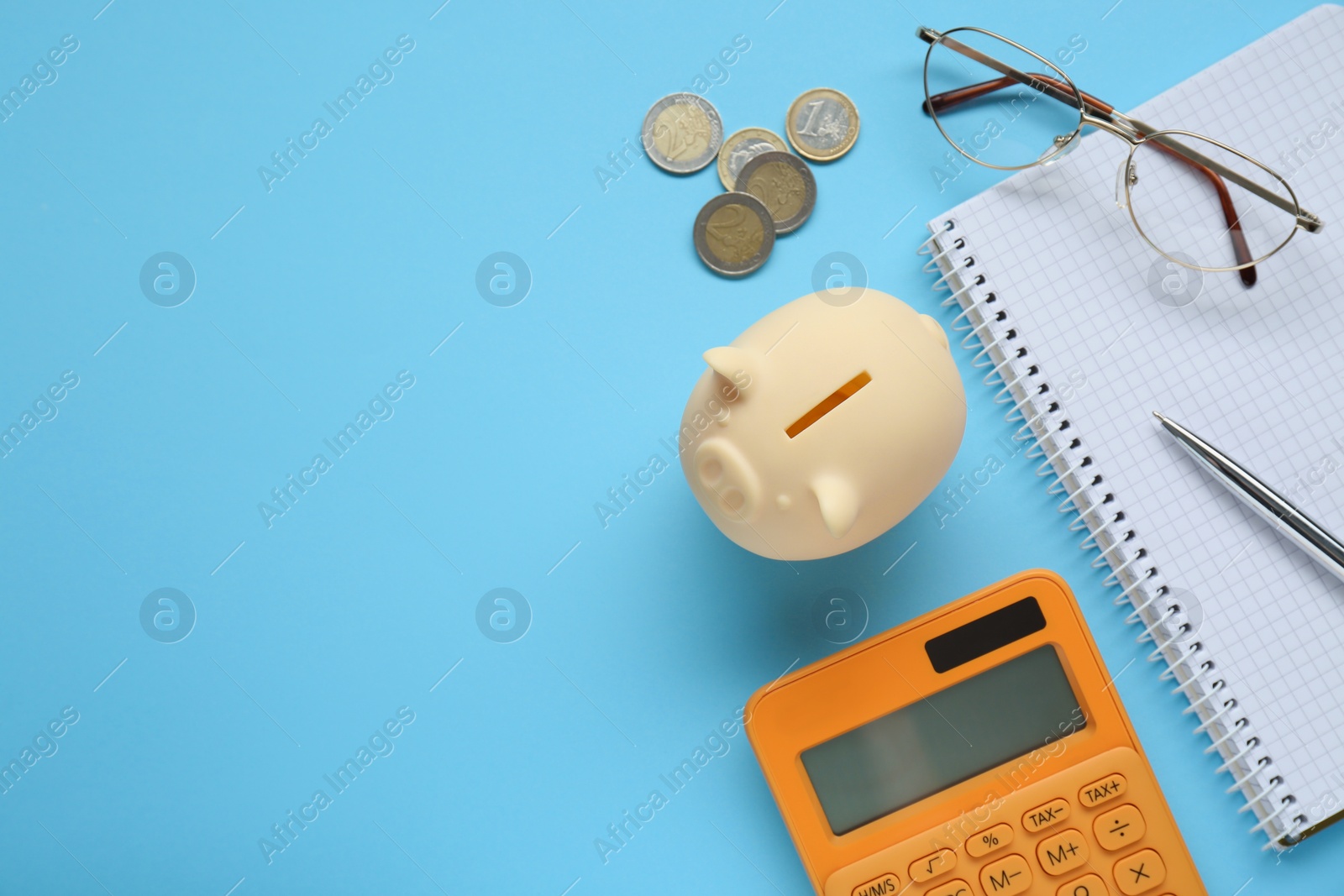 Photo of Flat lay composition with piggy bank and coins on light blue background. Space for text