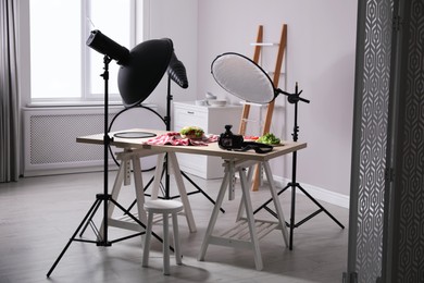 Photo of Professional camera and composition with tasty sandwich on table in photo studio. Food photography