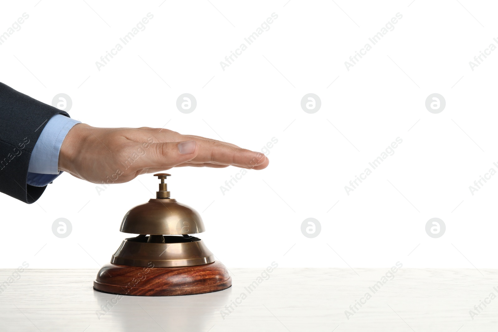 Photo of Man ringing hotel service bell at wooden table