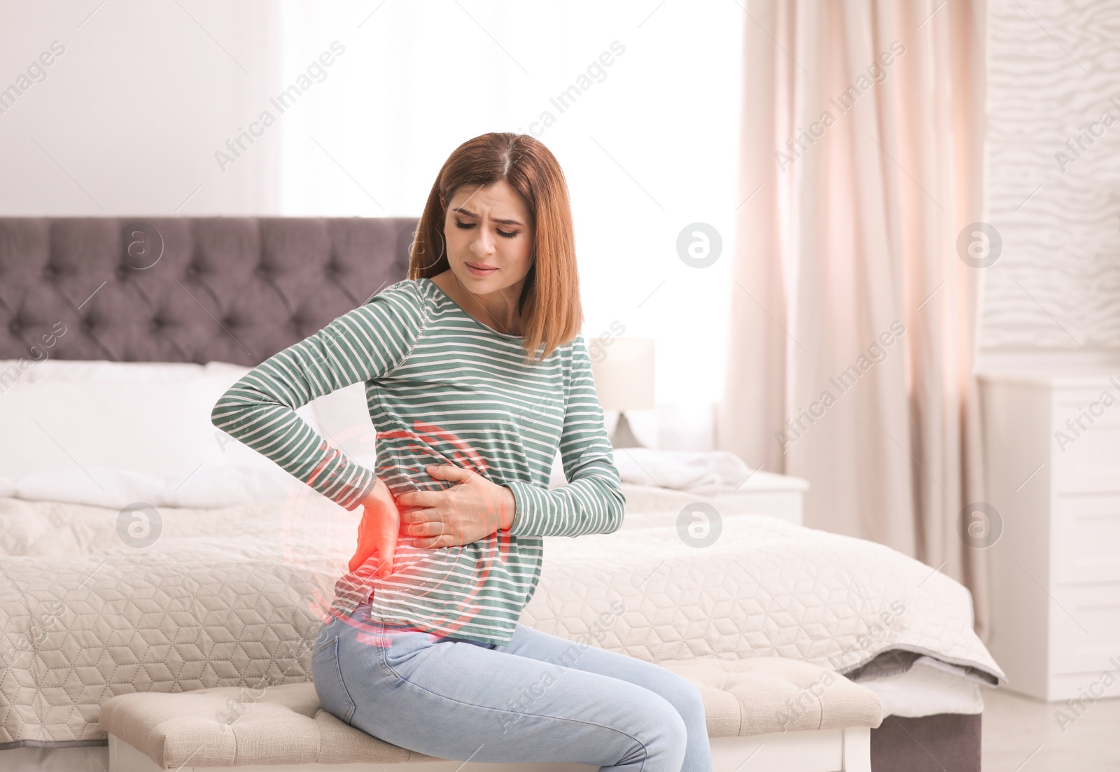 Image of Woman suffering from back pain after sleeping on uncomfortable mattress at home