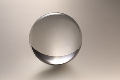 Photo of Transparent glass ball on light grey background