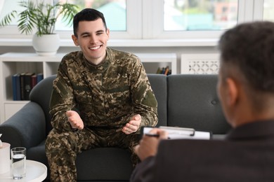 Photo of Professional psychotherapist working with military man in office