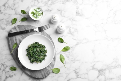 Photo of Flat lay composition with cooked spinach and space for text on white marble table. Healthy food