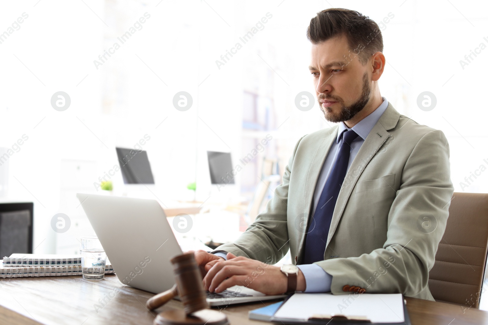 Photo of Male lawyer working with laptop in office