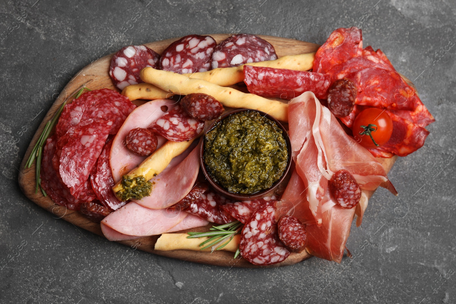 Photo of Tasty ham with other delicacies served on grey table, top view