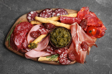Photo of Tasty ham with other delicacies served on grey table, top view