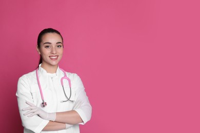 Photo of Portrait of beautiful young doctor on pink background. Space for text
