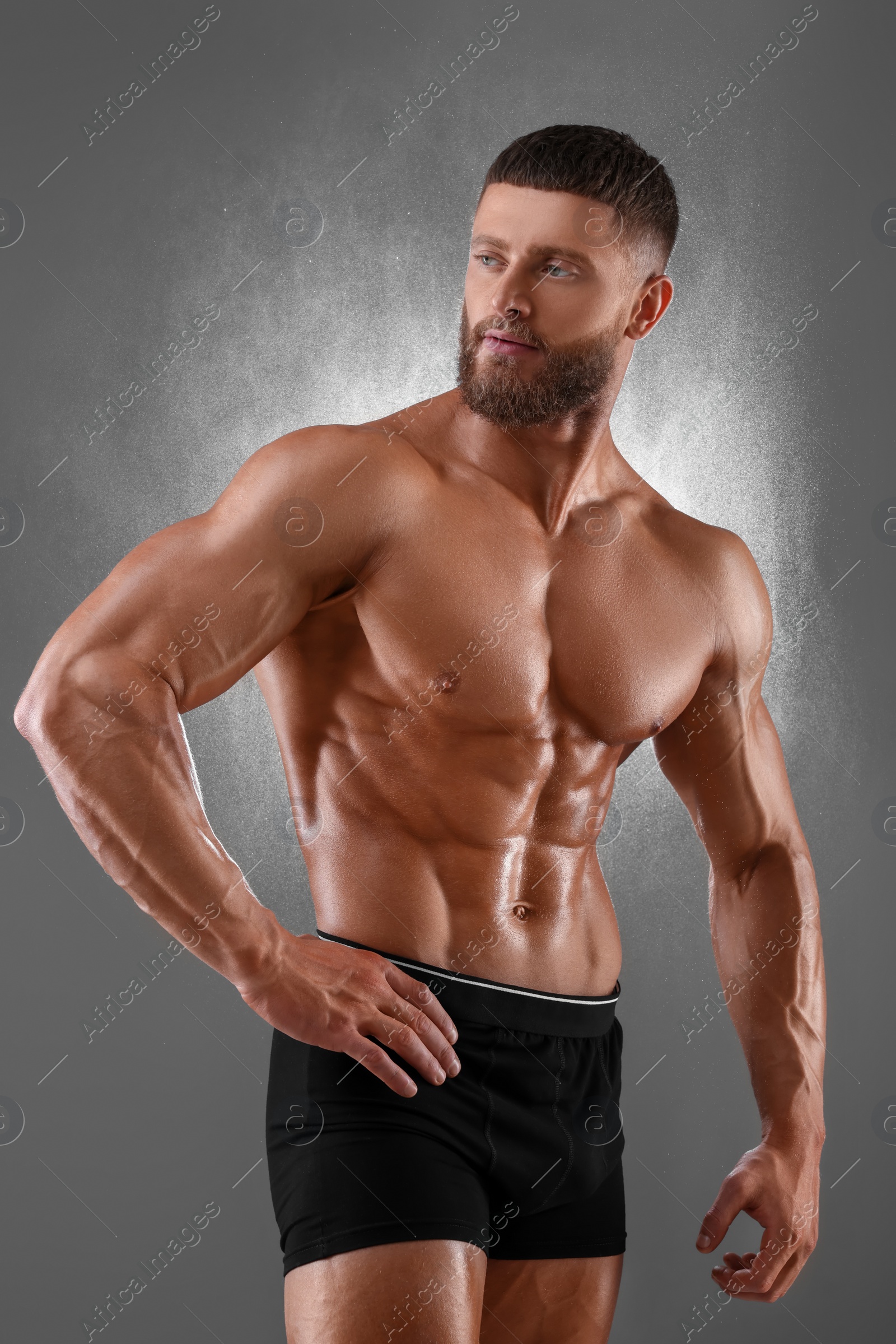 Photo of Young bodybuilder with muscular body on grey background