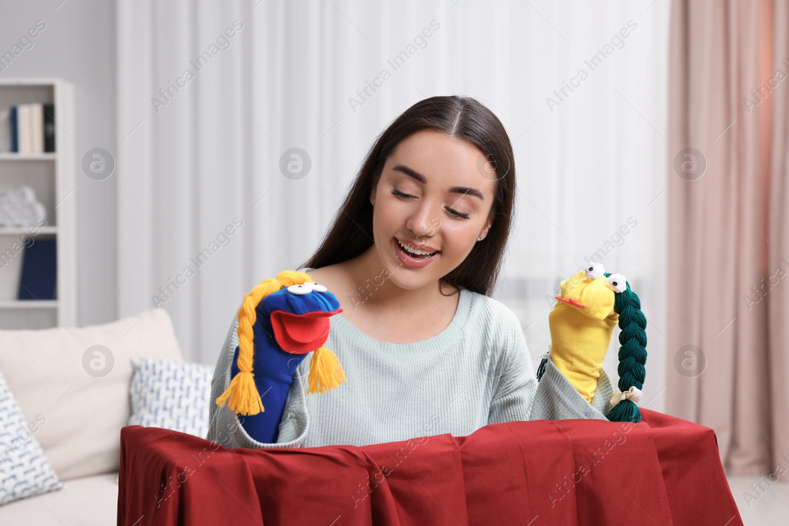 Photo of Happy woman performing puppet show at home